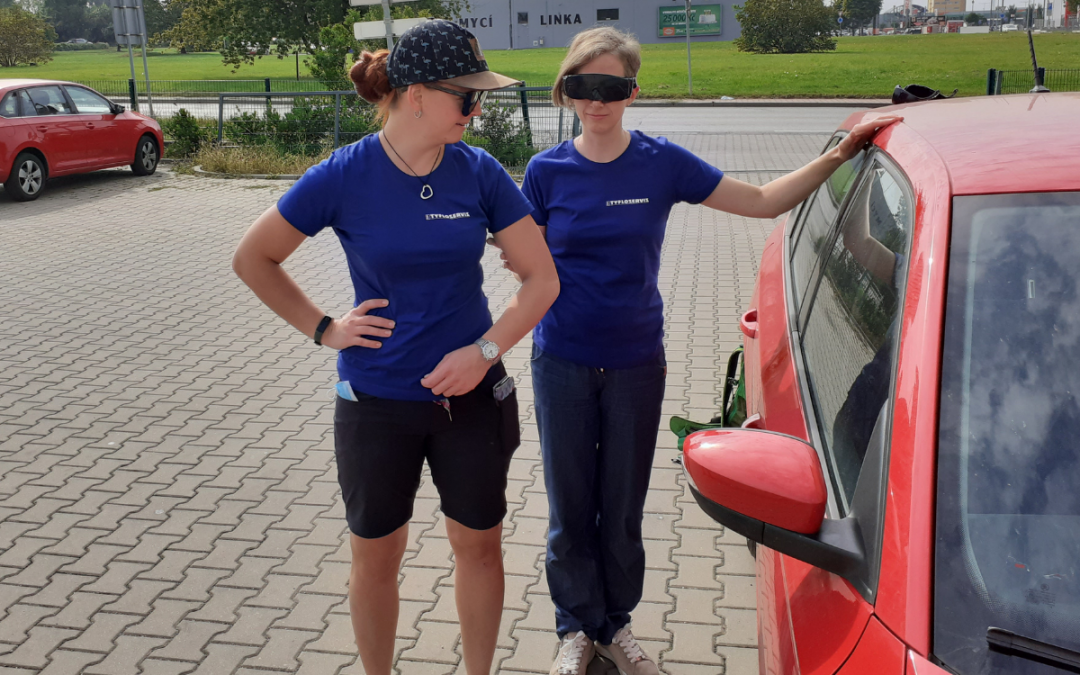Dvě instruktorky, jedna s klapkami na očích, druhá ji provází k autu, jedná se o nácvik prostorové orientace
